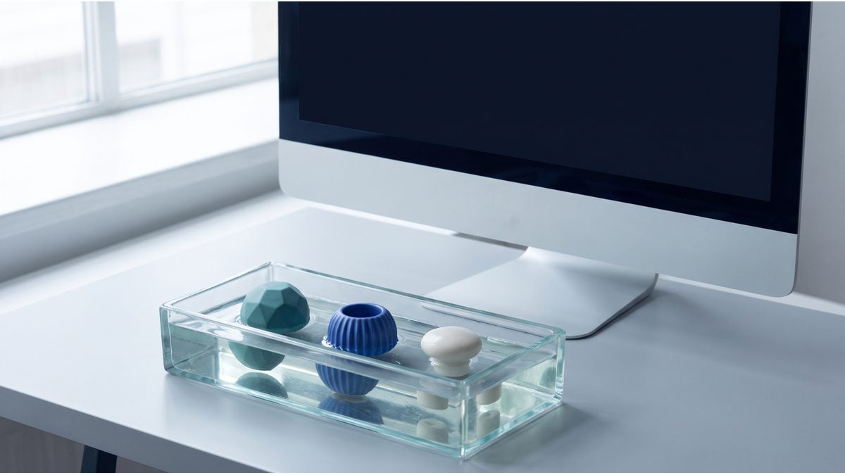 A blank-screen workstation beside three objects in a glass mould, illustrating inspection of a recorded workflow