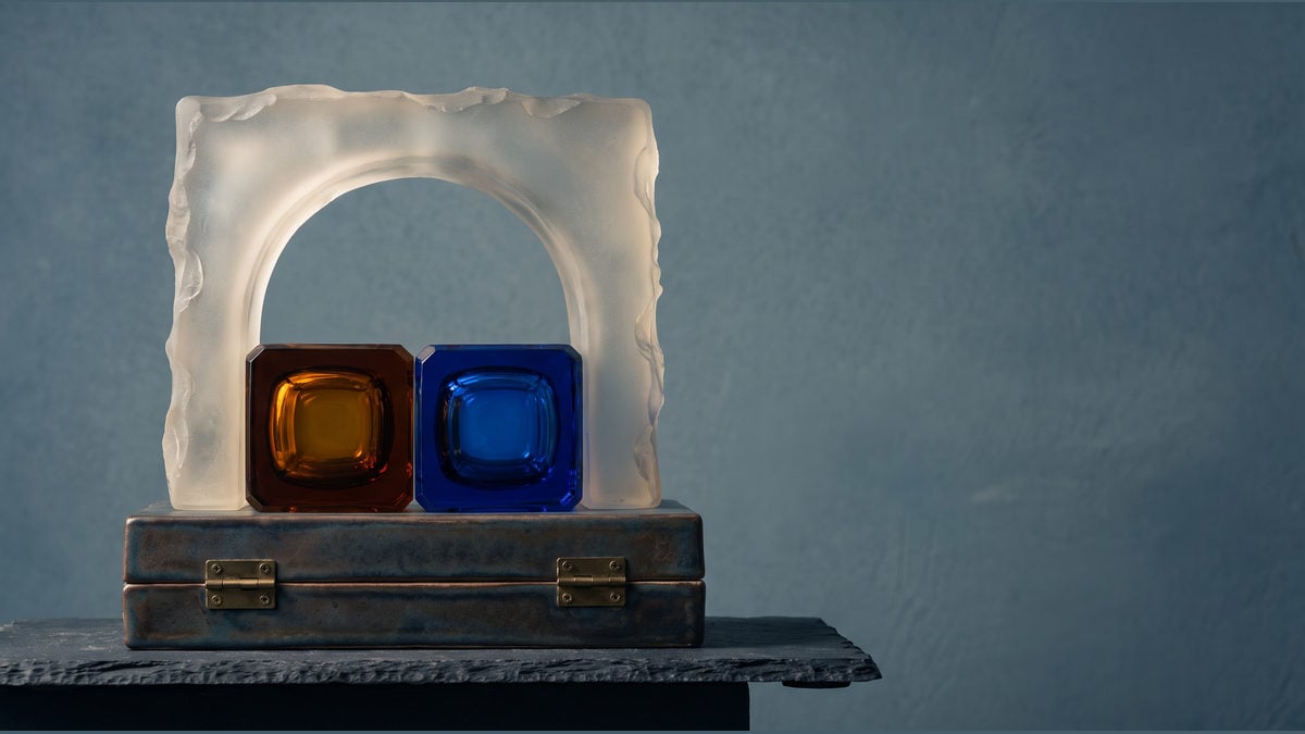 Two translucent capability capsules held apart by a gateway arch above a closed verification case.